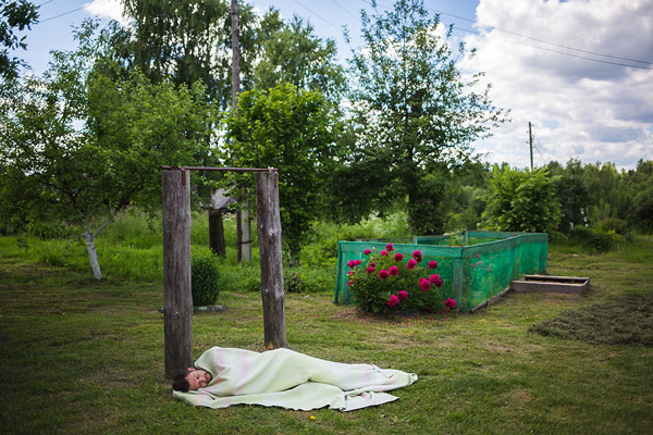 Producer and photographer Mikhail Mordasov naps outside Elizaveta Andreyevna's home.