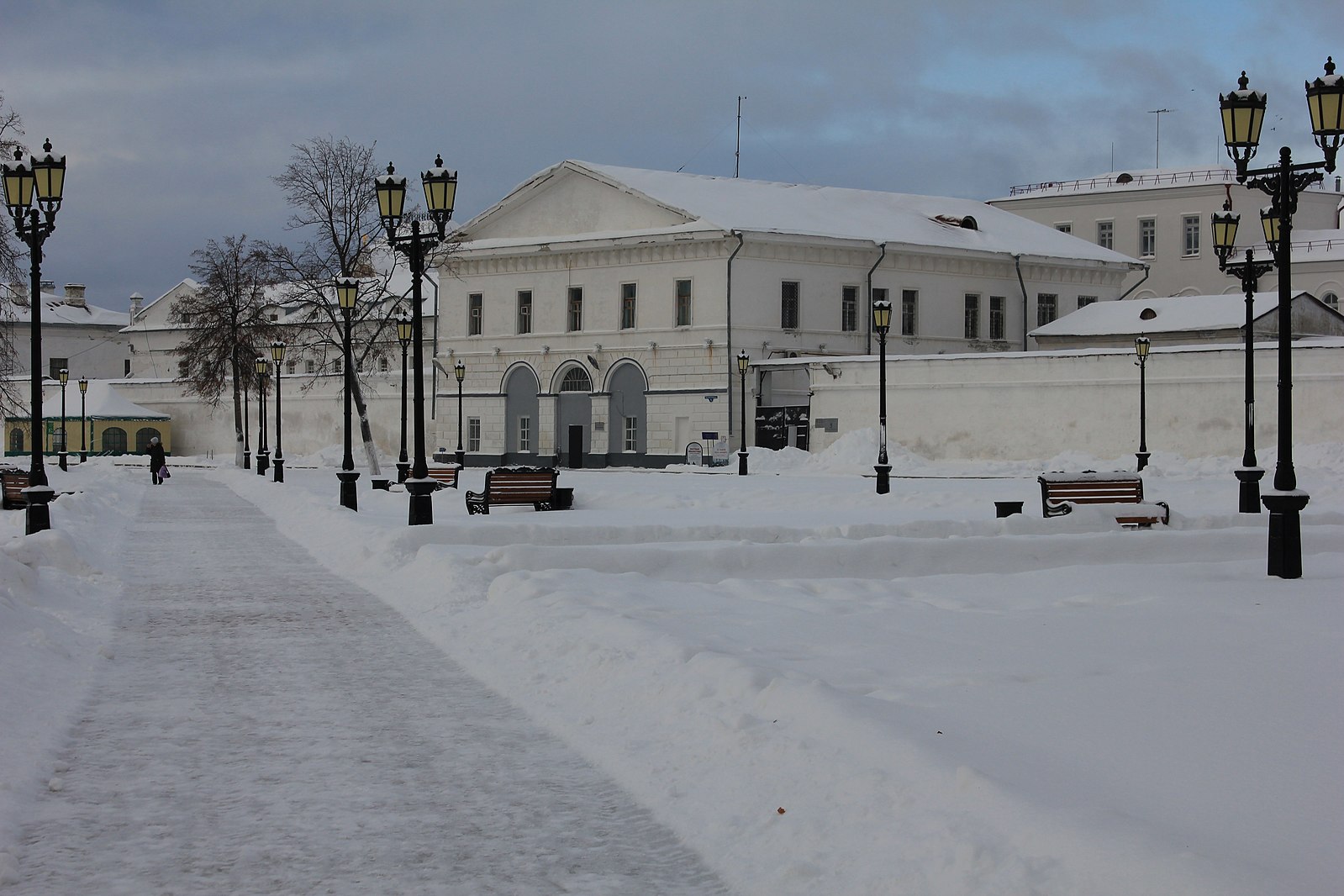 A white dreary building in the snow. 