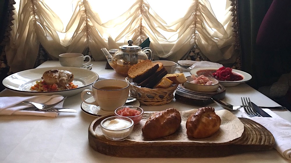 A cozy meal of pirozhki, borscht, tea, and sour cream.  