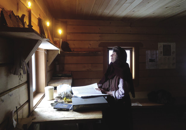 Woman praying in a cabin.