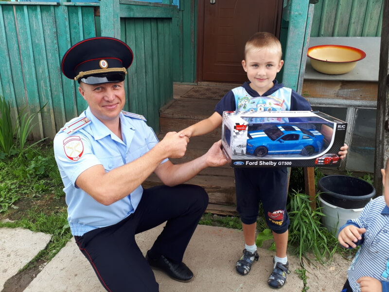 Russian police officer gifts a child a toy car