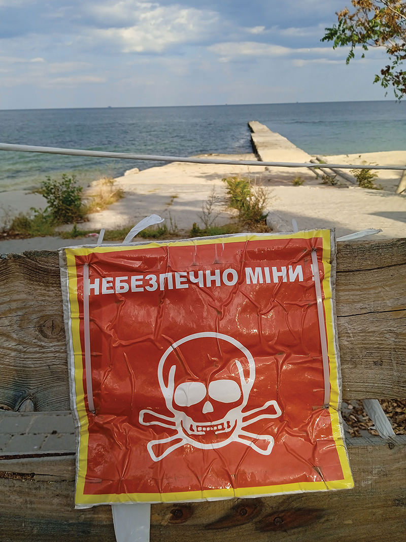 Sign warning of mines on beach.