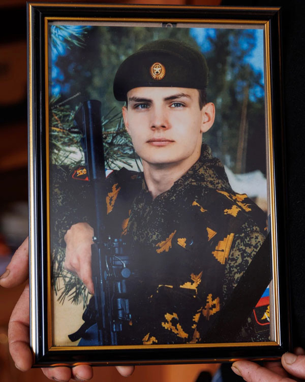 Young man in a uniform, in a photo held by his mother.
