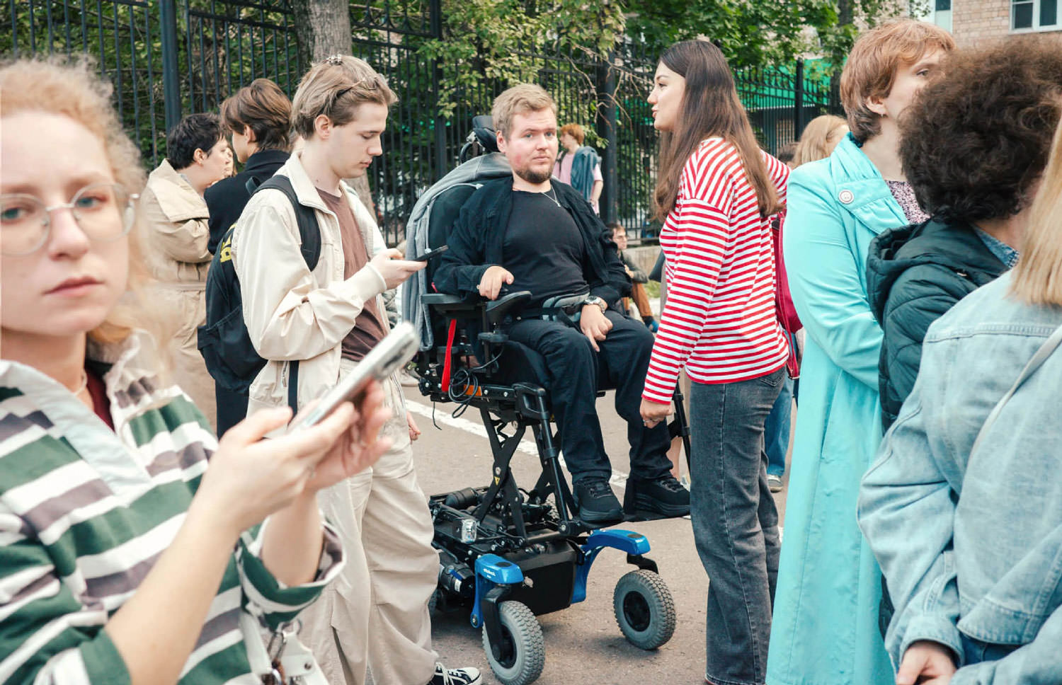 Man in wheelchair amongst a crowd.