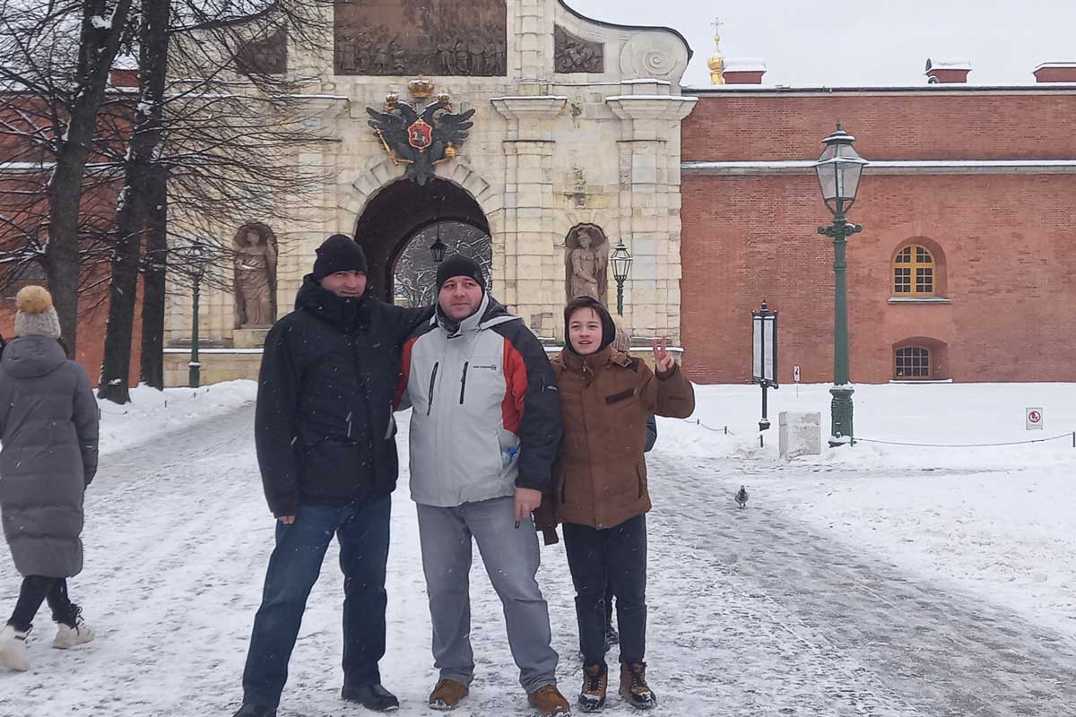 Three people standing in front of a tourist site.