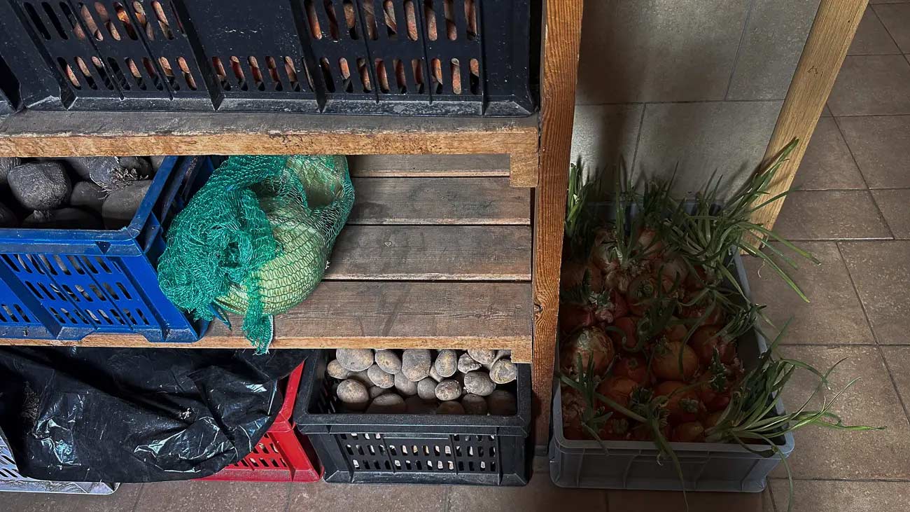 More vegetables under a cutting board.