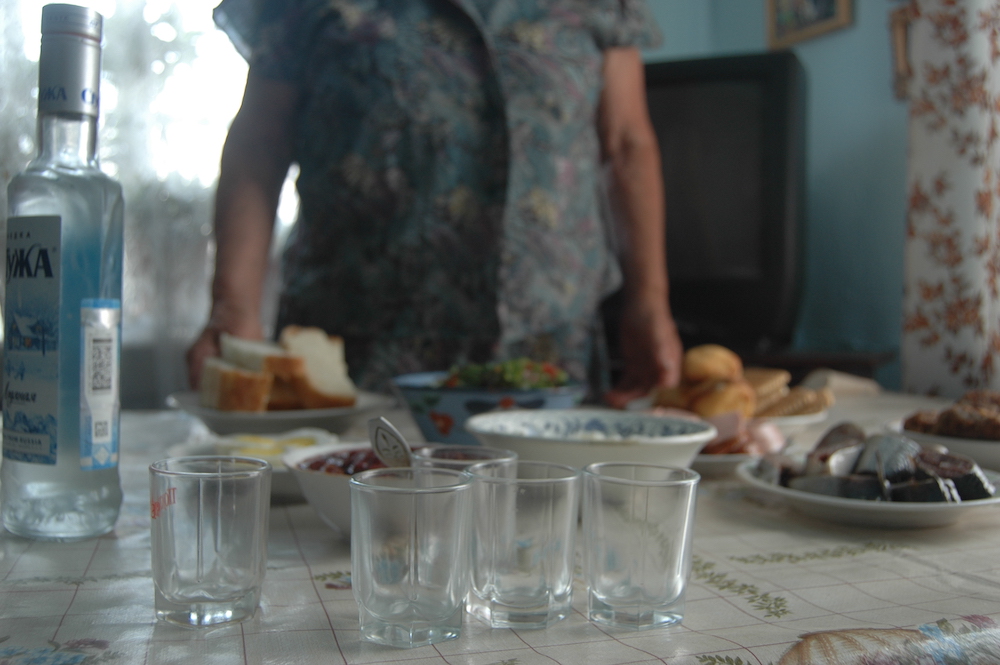 Shot glasses and a bottle of vodka sit on a table.